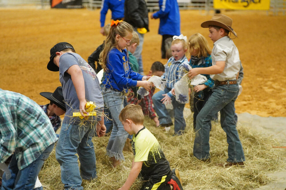 Children digging in hay looking for prizes.
