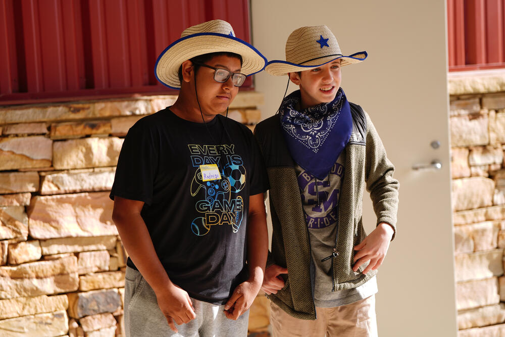 2 young males dressed in western attire attending the exceptional needs rodeo activities. 