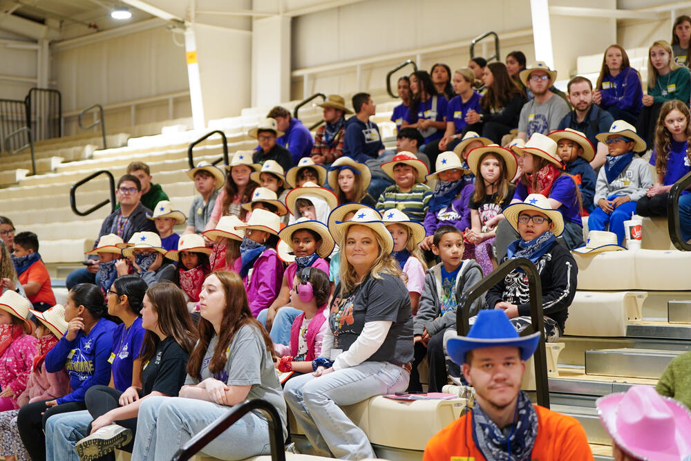Kids and chaperones sitting in the stands watching the exceptional needs rodeo.