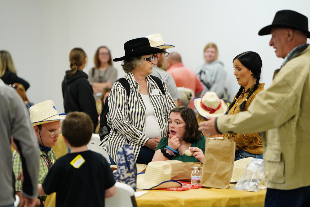 Chaperones and kids dressed in western attire eating lunch after the exceptional needs rodeo.
